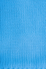 Fototapeta premium Blue knitted texture macro photo. Knitted clothes as background.