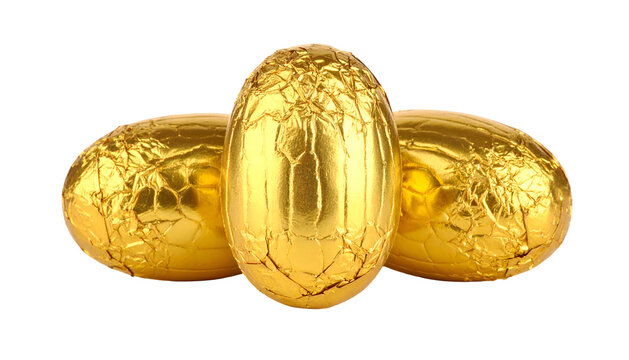 Three golden foil-wrapped egg-shaped treats, arranged closely together, on a black background