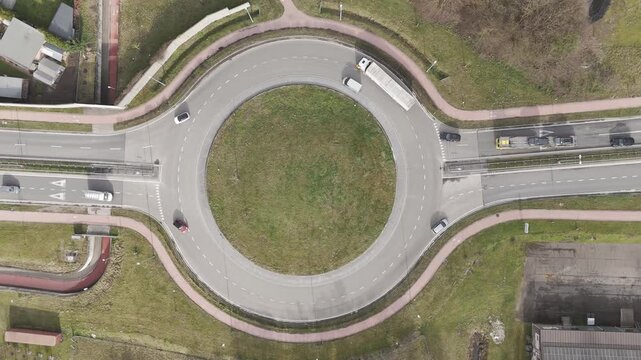 Genk, Belgium. Top-down drone hoovering over busy roundabout with flowing traffic and transport vehicles