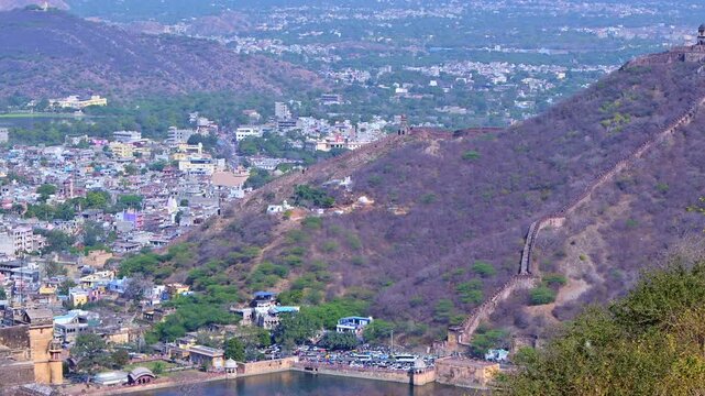 Daytime aerial view from Jaigarh Fort Jaipur showing Amer Fort, Maota Lake, Amer town houses, Aravalli hills, fort walls on mountains and scenic city landscape of Jaipur Rajasthan India.