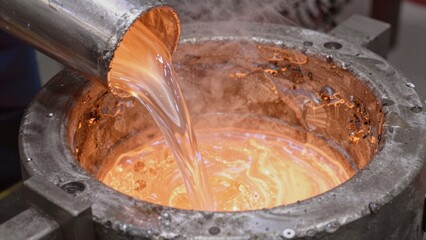 Fototapeta premium High-resolution taken laboratory setting close-up molten metal poured large round metallic vessel reddish-oran