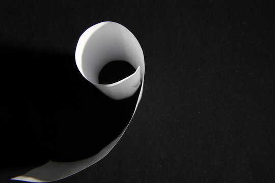 Curvas de papel para impresora con luz lateral de color blanco, forman un cilindro con el ala desplegada,  presentan un hermoso dise&ntilde;o abstracto con fondo negro.