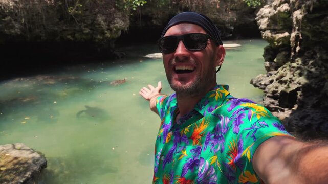 happy man traveler wear vibrant tropical shirt takes a selfie at the Baraka Natural Aquarium. High-energy shot capturing joy and freedom in a secluded Zanzibar turtle sanctuary