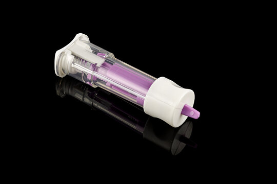 Medical scarifier isolated on black background. Automatic lancet scarifier for painless blood sampling. Blood test.