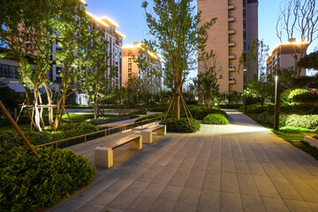 Modern residential park at night with stone bench and garden - Serene lifestyle concept © syu
