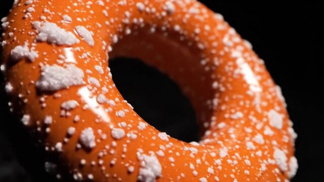 Abstract orange torus shape with white speckles on dark background