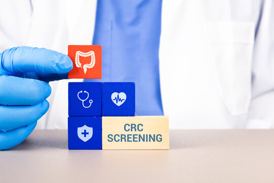 Large intestine, CRC screening, and global awareness in colorectal cancer prevention. The doctor's hand arranges the wooden cubes with the intestine icon.