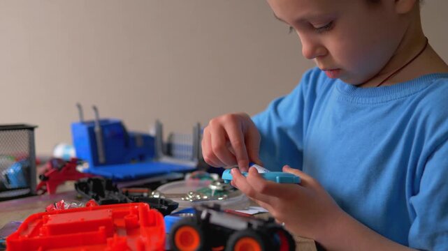 Focused Child Changing Batteries in Electronic Toy, Boy Replacing AA Power Cell at Desk, Hands-on Maintenance and Practical Skills for Kids