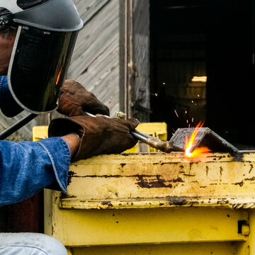 Welder Using Torch with Sparks Showing Industrial Work and Skill