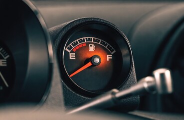 Naklejka premium Car Fuel Gauge Showing Near Empty Low Fuel Warning On Vehicle Dashboard Close-Up 