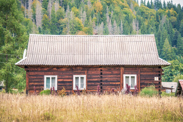 Fototapeta premium Old wooden house with white windows in a mountain Carpathian village 