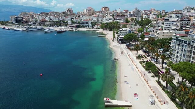 4K Aerial Drone View of Saranda, Albania &ndash; Coastal Promenade, Palm Trees, Beach, Ferris Wheel, Marina with Yachts and Ferry, Ionian Sea Cityscape