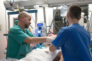 Obraz premium Doctors monitoring patient in hospital intensive care unit