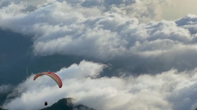 Paraglider launching from Babadag mountain and flying above clouds over Oludeniz at sunset, capturing adventure travel, extreme sport, aerial motion, freedom and dramatic coastal landscape