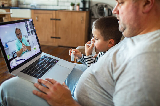 Father and sick son consult doctor via video at home