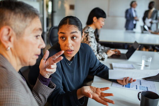 Coworkers discussing project details in office