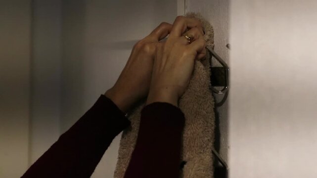 hands hanging clothes on the coat rack