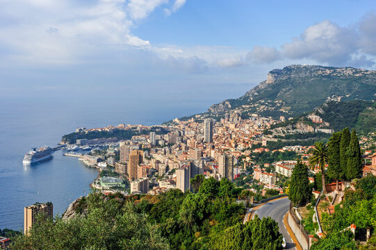View of the coastline and cityscape of the Principality of Monaco from the Corniche with clear skies and sea in the background