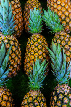 Fresh pineapples arranged neatly in a display on a surface in France during the daytime