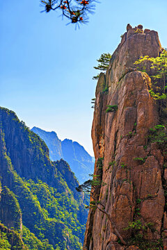 Huangshan Mountain area with steep cliffs and trees under a clear sky in Anhui Province, China
