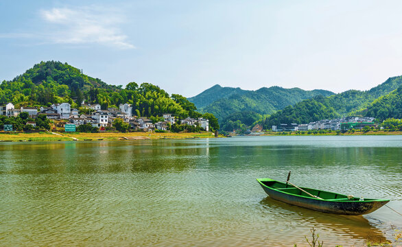 Green boat floats on XinAn River near WuFuShan Village in Huangshan, Anhui Province, China during a sunny day in summer
