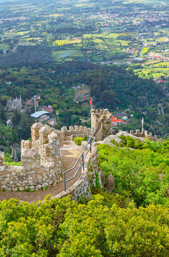 Explore the ancient walls of Castelo dos Mouros overlooking the stunning landscape of Sintra in Portugal