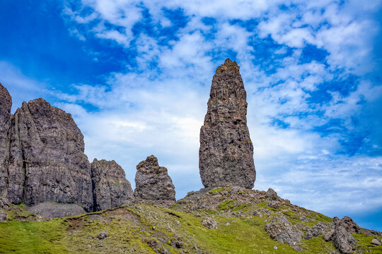 Rock formation rises on a hill in the Trotternish escarpment of the Isle of Skye in Scotland with cloudy sky