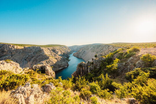 View of the Zrmanja River Canyon in Croatia, with winding turquoise waters cutting through limestone cliffs. A scenic natural wonder popular for kayaking and hiking