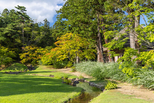 Garden and stream at Motsuji Temple in Hiraizumi, Iwate, Japan during daylight with trees and grass