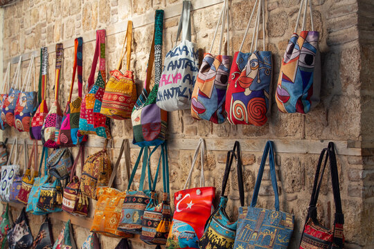Colorful tote bags displayed for sale in a market in Antalya, showcasing local crafts and designs