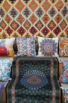 Bright carpets and decorative pillows for sale in Kaleici area of Antalya, Turkey, showcasing traditional designs and patterns