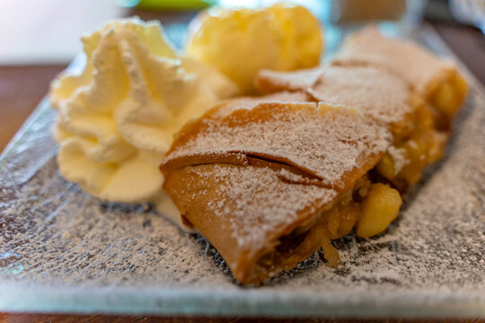 Savoring apple strudel dessert in town center of Kaprun during summer in Austria