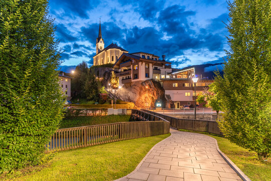 View of church at dusk with trees and path in Kaprun during summer, located in Zell am See, Salzburg, Austria