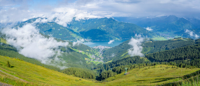 View of Zell am See from Schmittenhohebahn top station on a sunny day with clouds in the background in Austria