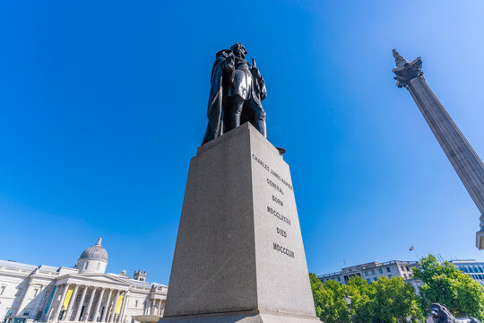 Charles Napier statue and Nelsons Column stand in Trafalgar Square during a summer day in Westminster, London, England, United Kingdom