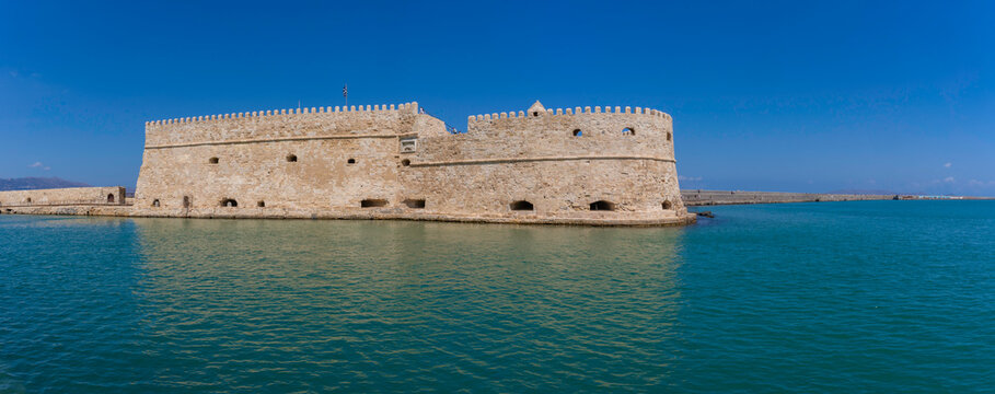 Koules Venetian Fortress stands in clear waters under a sunny sky in Crete, Greece
