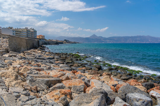 Bright sunny day along the coastline near Heraklion, showcasing clear waters and rocky shore