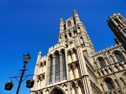 Ely Cathedral stands tall against a clear blue sky with unique architectural details and surrounding elements visible