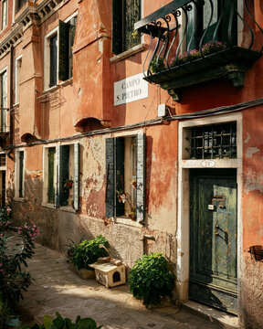 Exploring a quiet alley with aged walls and green plants in Venice, Italy