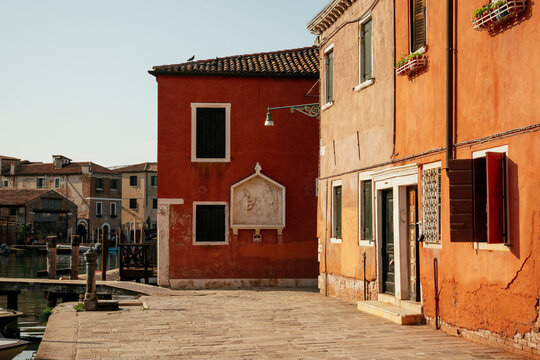Exploring the quiet streets of La Tana in Venice, showcasing colorful buildings along the canal in the morning light