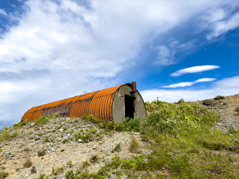 Remains of World War II bunker at abandoned site in Dutch Harbor in Unalaska, Alaska with blue sky