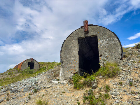 Remains of World War II bunkers stand abandoned in Dutch Harbor, Unalaska, Alaska along a rugged landscape
