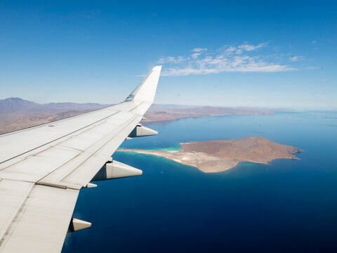 View of Isla Coronado from a commercial flight over Baja California Sur, Mexico showcasing the coastline and landscape below