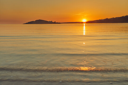 Sunset observed from Bantham showing Burgh Island and calm waters off the south coast of Devon in Great Britain