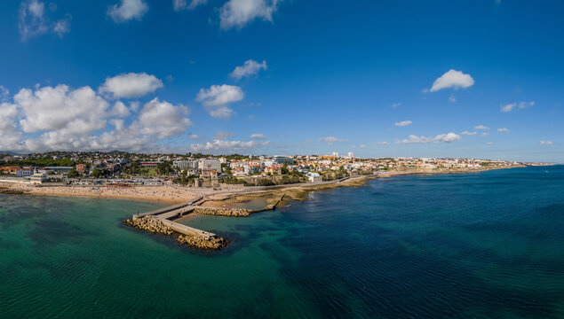 Panoramic view of Tamariz beach showcasing water, coastline, and city in Lisbon region of Portugal with clear skies