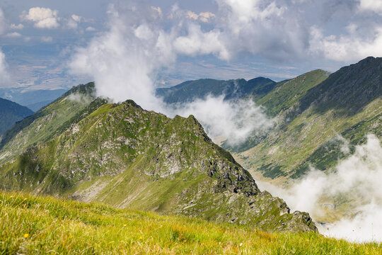 Fagaras Mountains view over Balea Lake showing rocky peaks and dense clouds in Romania