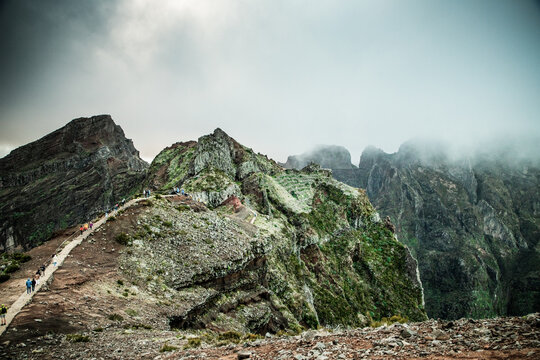 Explore the mountain landscape of Madeira Portugal with steep trails and lush greenery under a cloudy sky