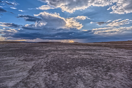 Storm clouds gather over the landscape near Petrified Forest National Park in Arizona while viewed from a gray plain