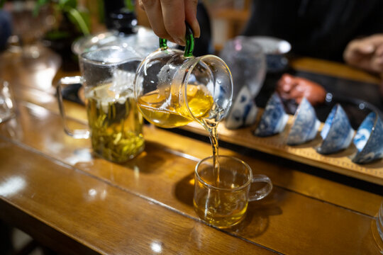 Tea ceremony in Shangli, Sichuan, with tea poured into a glass during a traditional gathering