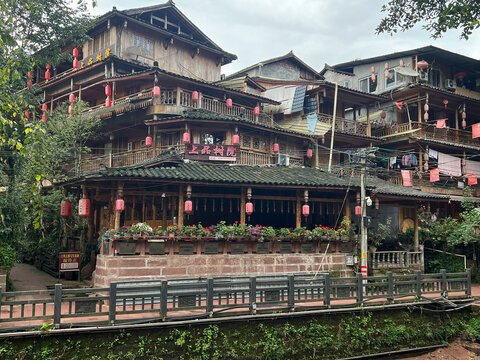 Old wooden house stands in the city with multiple balconies and lanterns in Shangli Sichuan China
